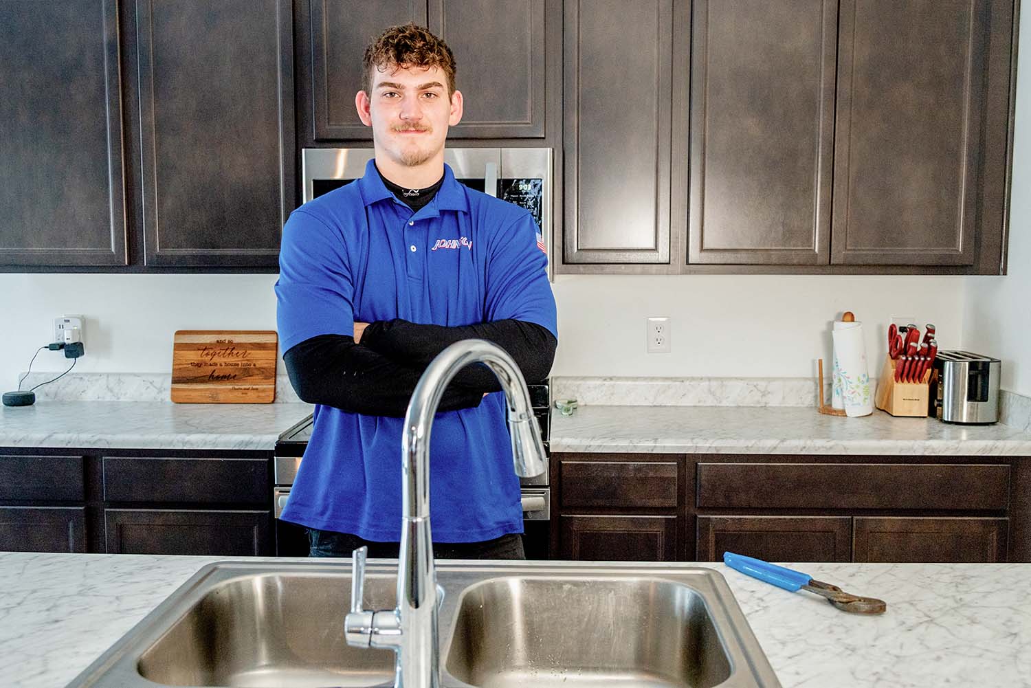 Johnson Heating, Cooling, and Plumbing plumber behind a fix faucet in Columbus