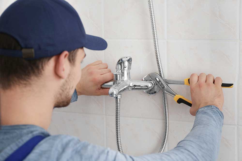 plumber installing shower tub fixtures