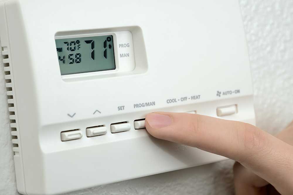 thermostat showing 71 degrees being adjusted